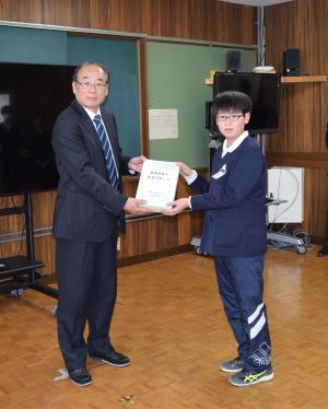 西脇町長に寄付を手渡す平群小6年児童