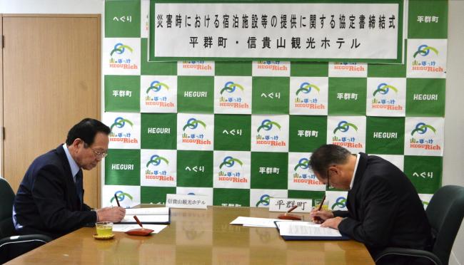 信貴山観光ホテルと協定書へ署名する様子